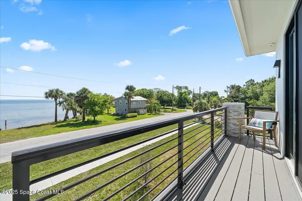a view of a balcony with wooden floor and fence