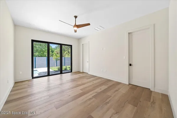an empty room with wooden floor and windows