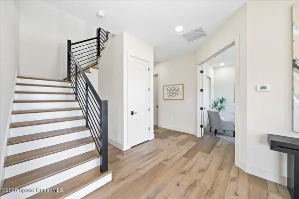 a view of a hallway with wooden floor and staircase