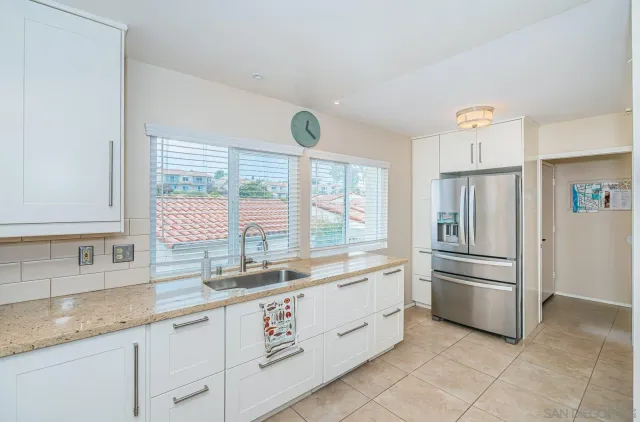 a kitchen with granite countertop a refrigerator and a sink
