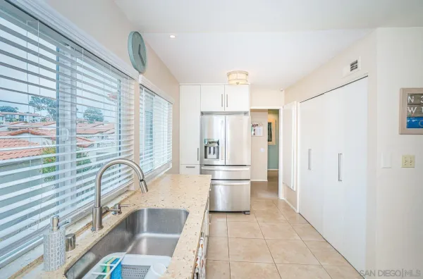 a kitchen with granite countertop a refrigerator and a sink