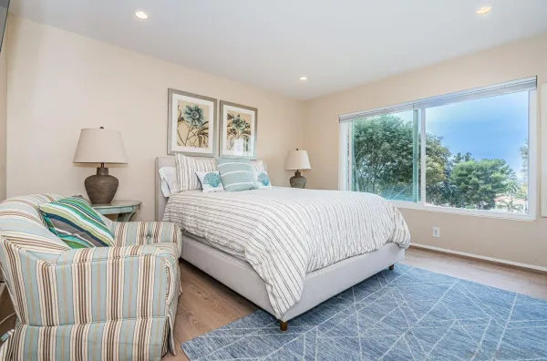 a bedroom with a bed and a large window