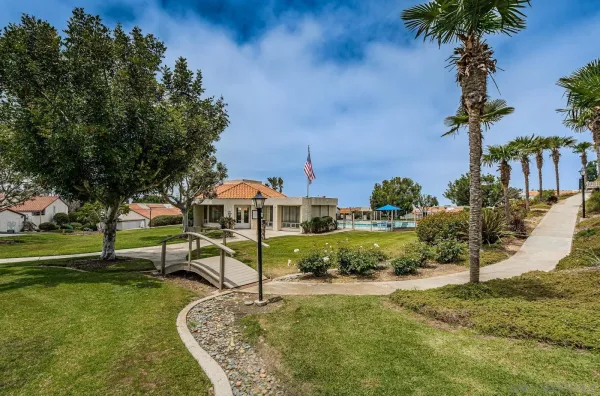 an aerial view of a house with a yard and lake view in back