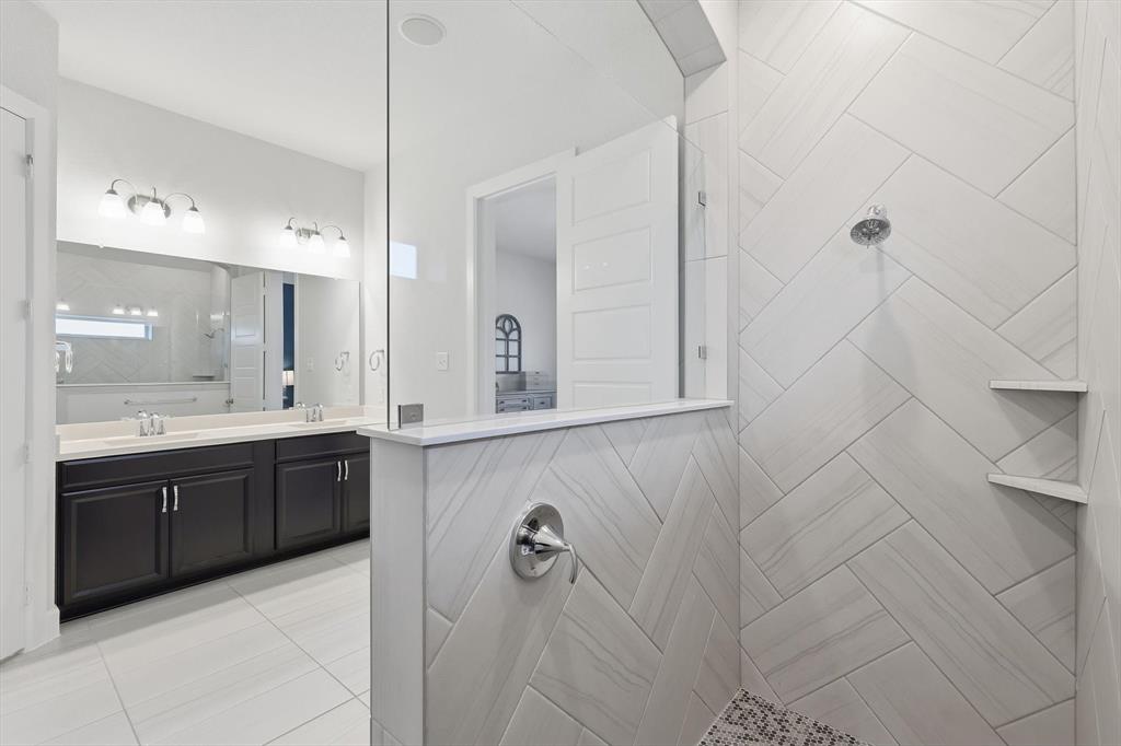 1701 Shetland Road Aubrey, TX 76227 - Photo 15 of 31 a bathroom with a double vanity sink a mirror and a bathtub