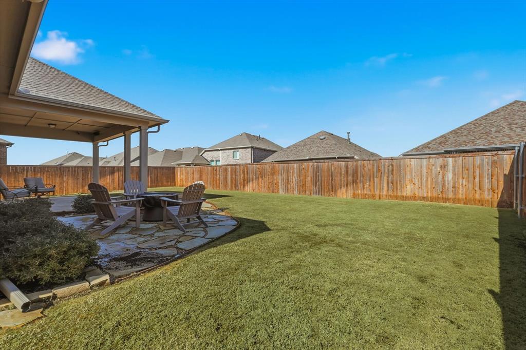 1701 Shetland Road Aubrey, TX 76227 - Photo 23 of 31 a view of a backyard with table and chairs under an umbrella