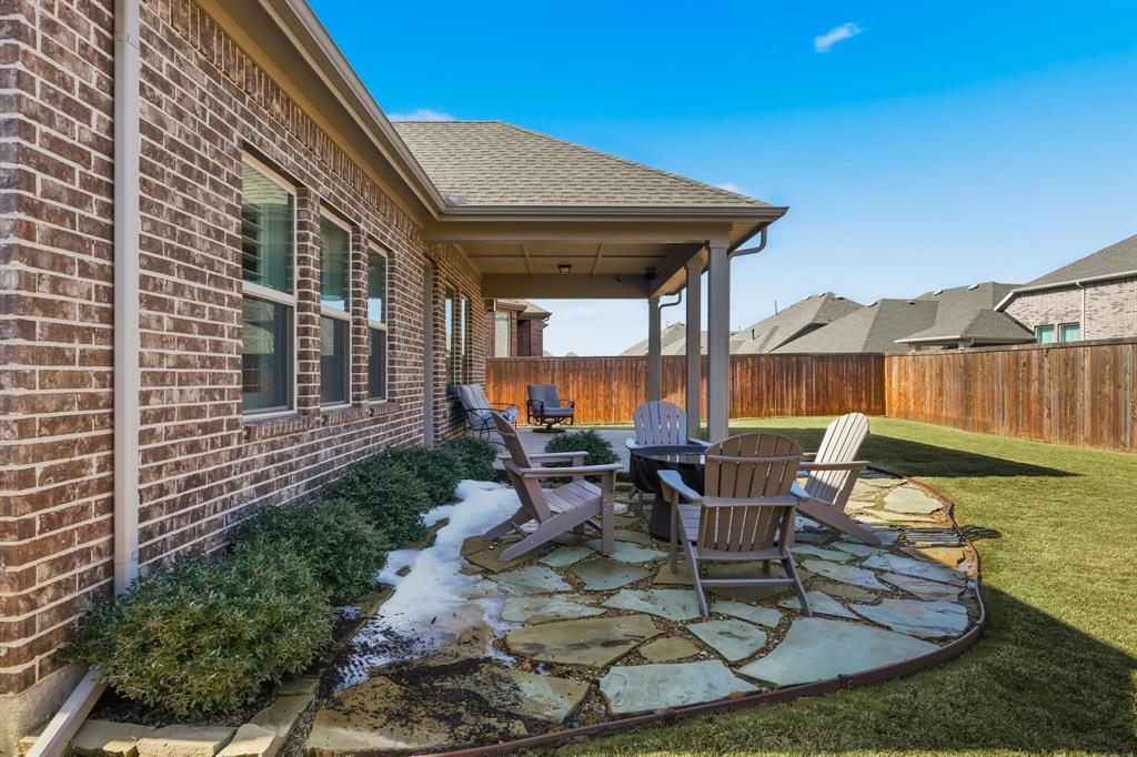 1701 Shetland Road Aubrey, TX 76227 - Photo 24 of 31 a view of a patio with table and chairs potted plants and floor to ceiling window