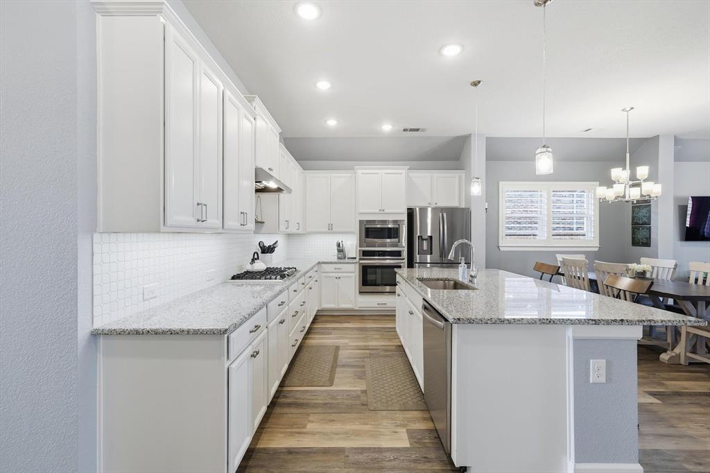1701 Shetland Road Aubrey, TX 76227 - Photo 6 of 31 a large kitchen with stainless steel appliances kitchen island granite countertop a sink and cabinets