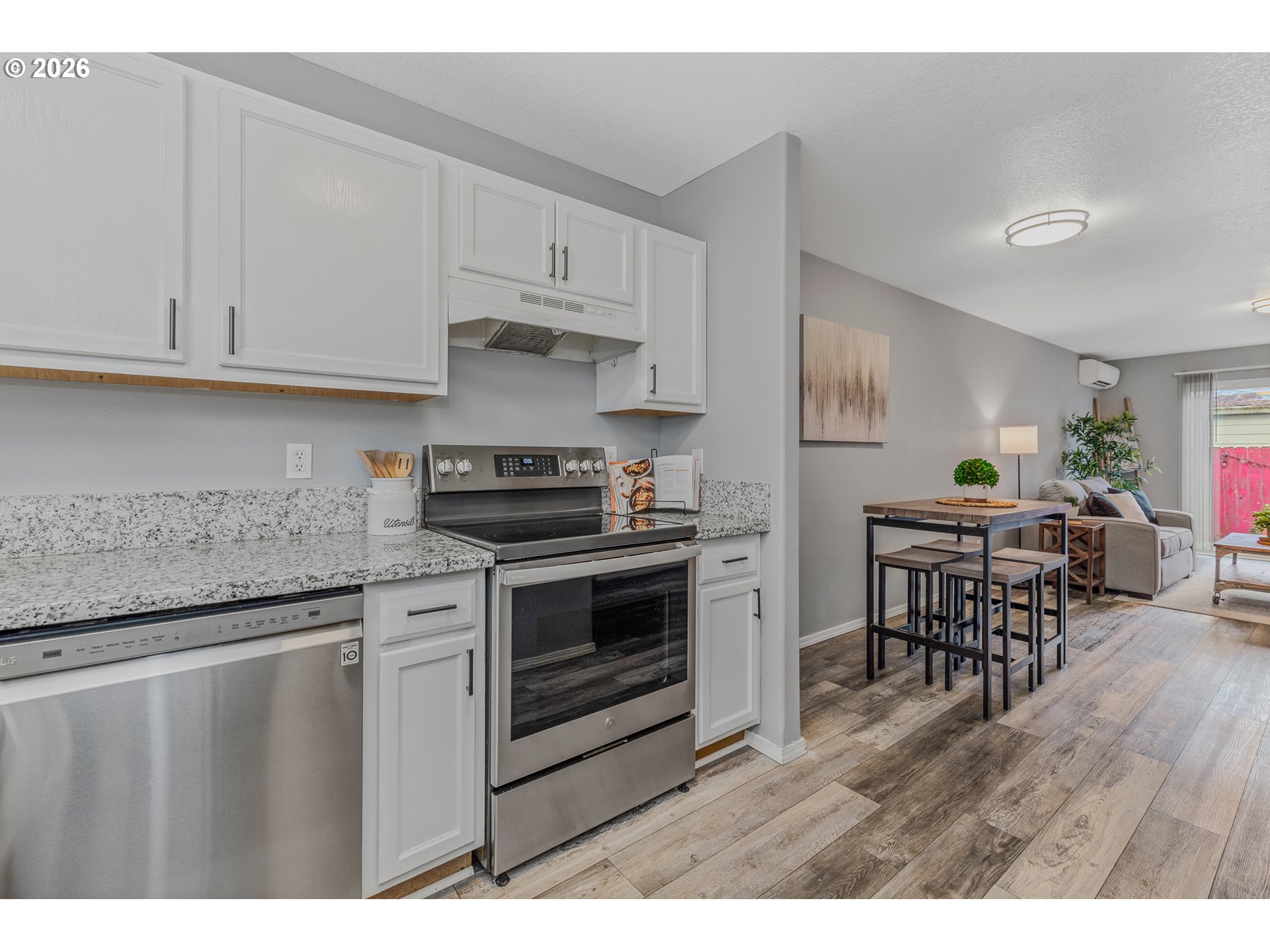 19159 Southeast Yamhill Street, Unit 15 Portland, OR 97233 - Photo 3 of 23 a kitchen with stainless steel appliances granite countertop a stove a sink a refrigerator and white cabinets