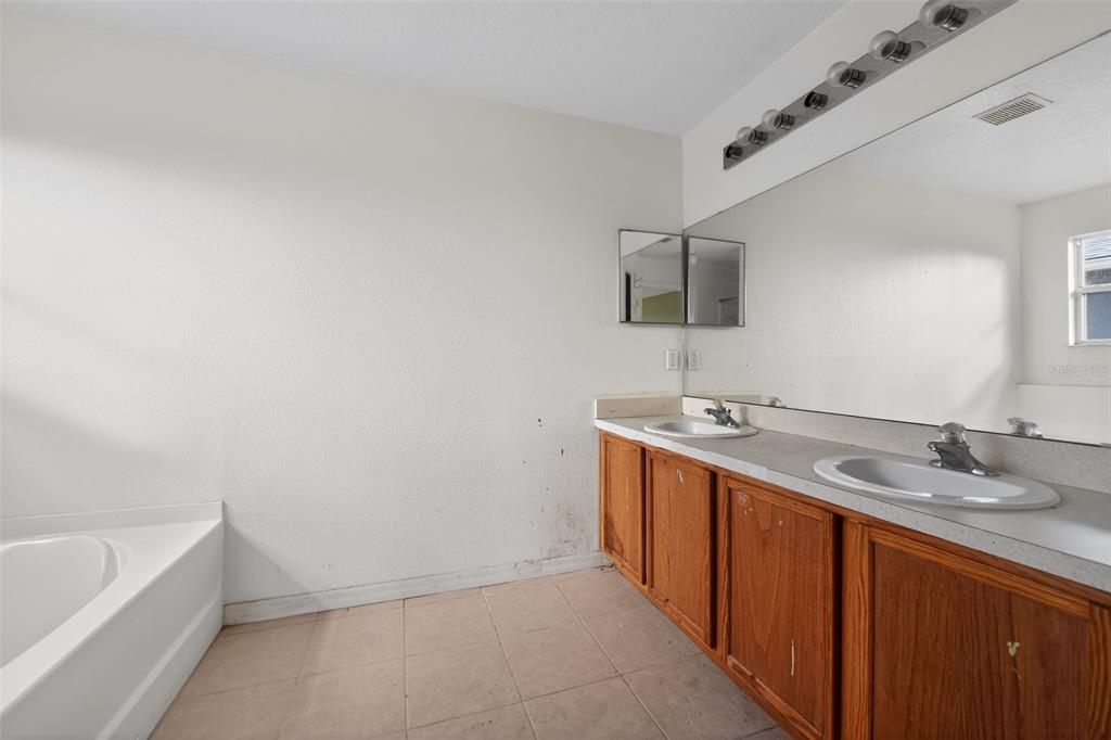 512 Flower Fields Lane Orlando, FL 32824 - Photo 11 of 28 a bathroom with a tub sink and mirror