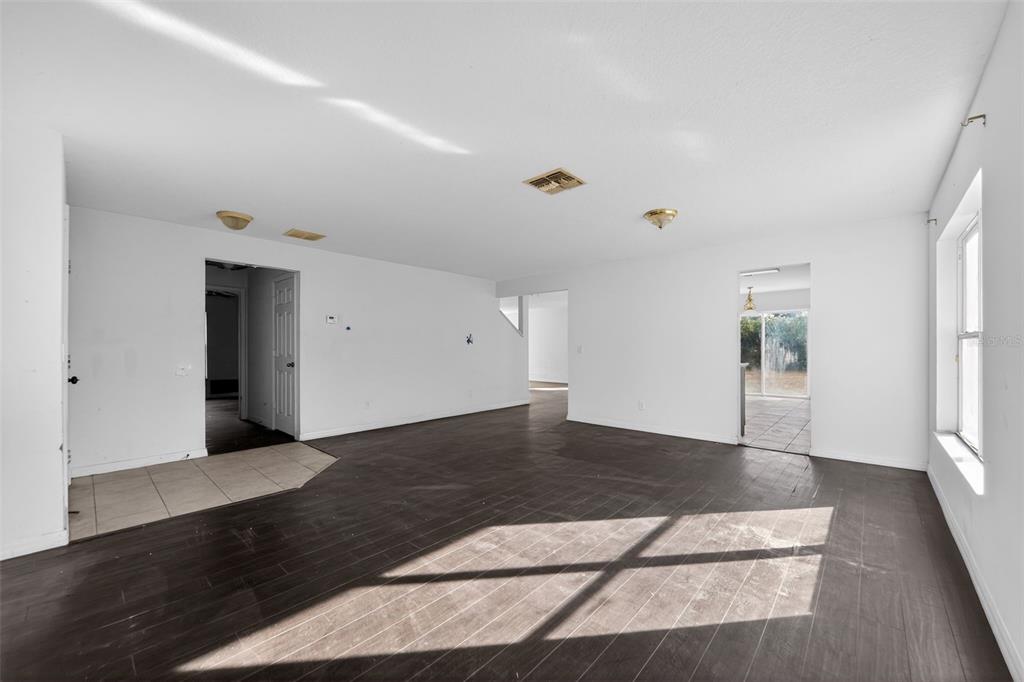 512 Flower Fields Lane Orlando, FL 32824 - Photo 4 of 28 a view of an empty room with wooden floor and a window