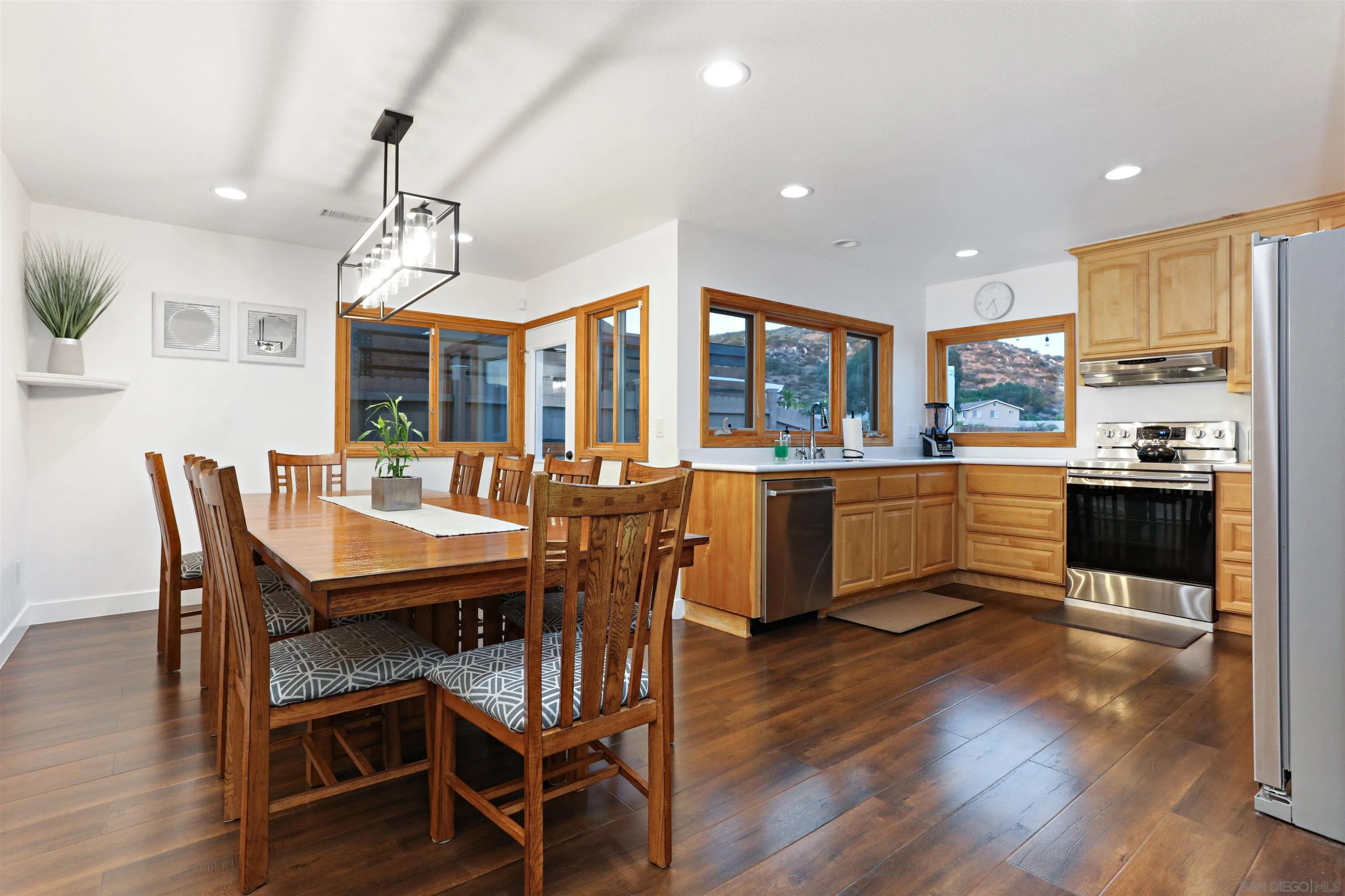 14607 Bowdoin Road Poway, CA 92064 - Photo 7 of 30 a view of a dining room and livingroom with furniture wooden floor a chandelier