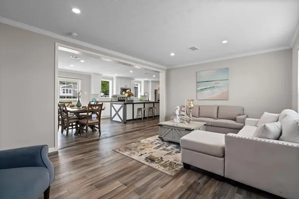 a living room with furniture wooden floor and dining table