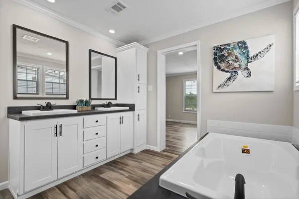 a bathroom with a tub a sink and mirror