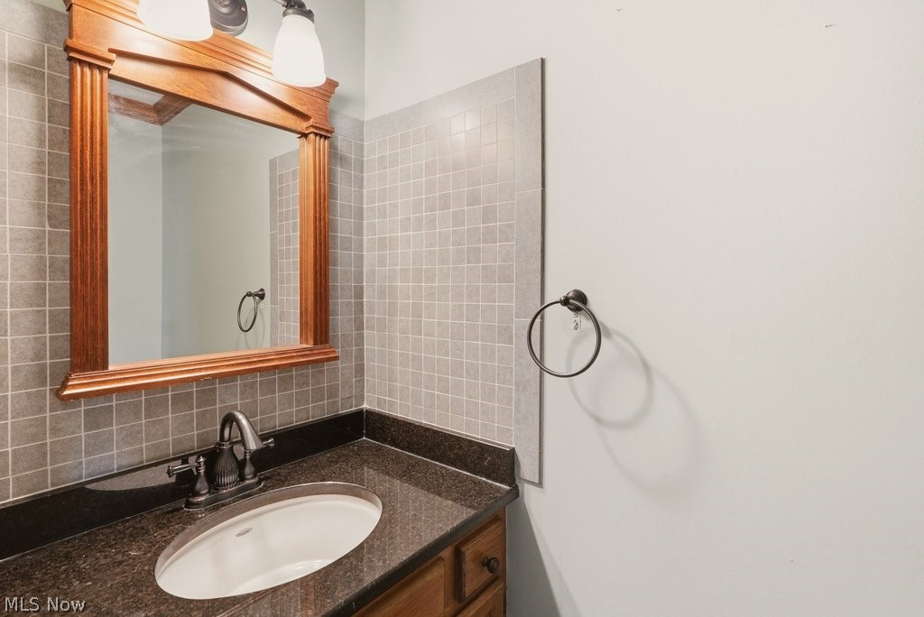 5321 Young Road Stow, OH 44224 - Photo 18 of 37 Vanity featuring a dark stone countertop, integrated oval sink, and oil-rubbed bronze faucet