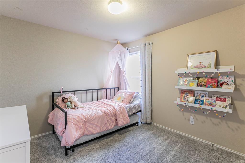 2210 Torch Lake Drive Forney, TX 75126 - Photo 15 of 29 a bed room with a bed and a book shelf