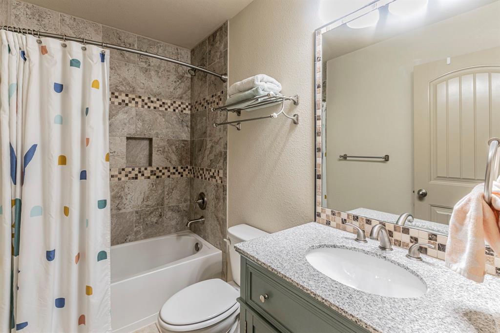 2210 Torch Lake Drive Forney, TX 75126 - Photo 16 of 29 a bathroom with a granite countertop bathtub shower sink vanity and toilet