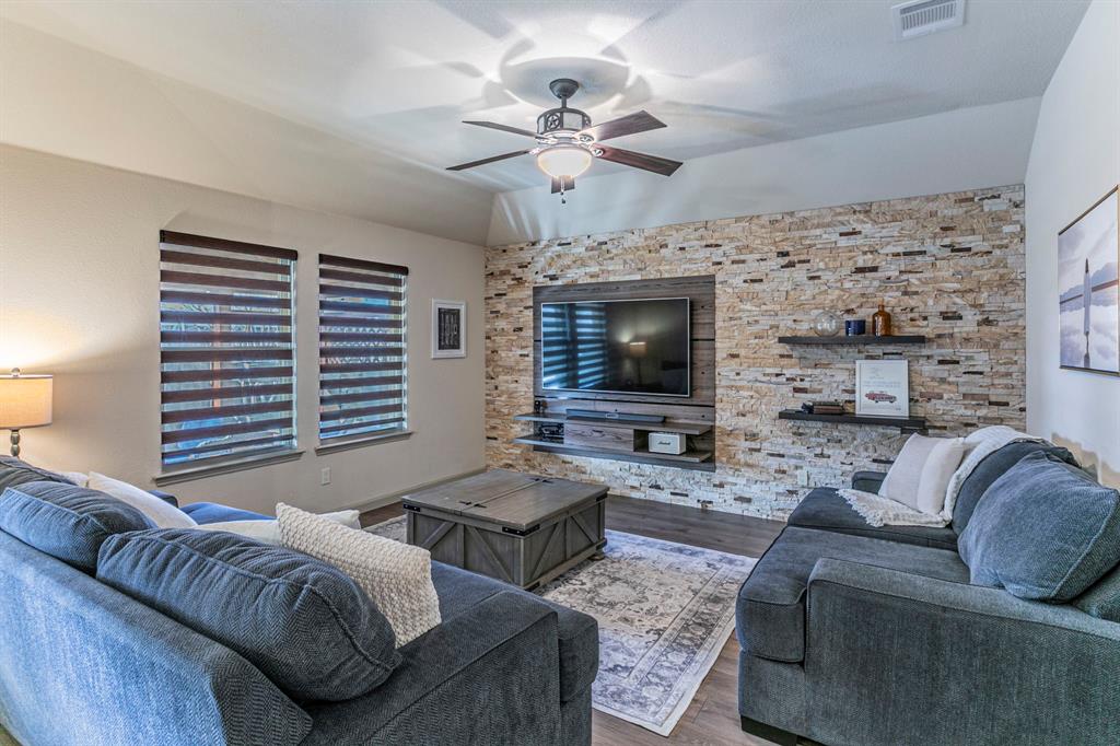 2210 Torch Lake Drive Forney, TX 75126 - Photo 4 of 29 a living room with furniture a fireplace and a flat screen tv