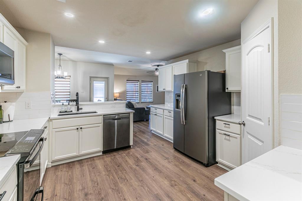 2210 Torch Lake Drive Forney, TX 75126 - Photo 7 of 29 a kitchen with a refrigerator a sink dishwasher with a dining table and chairs