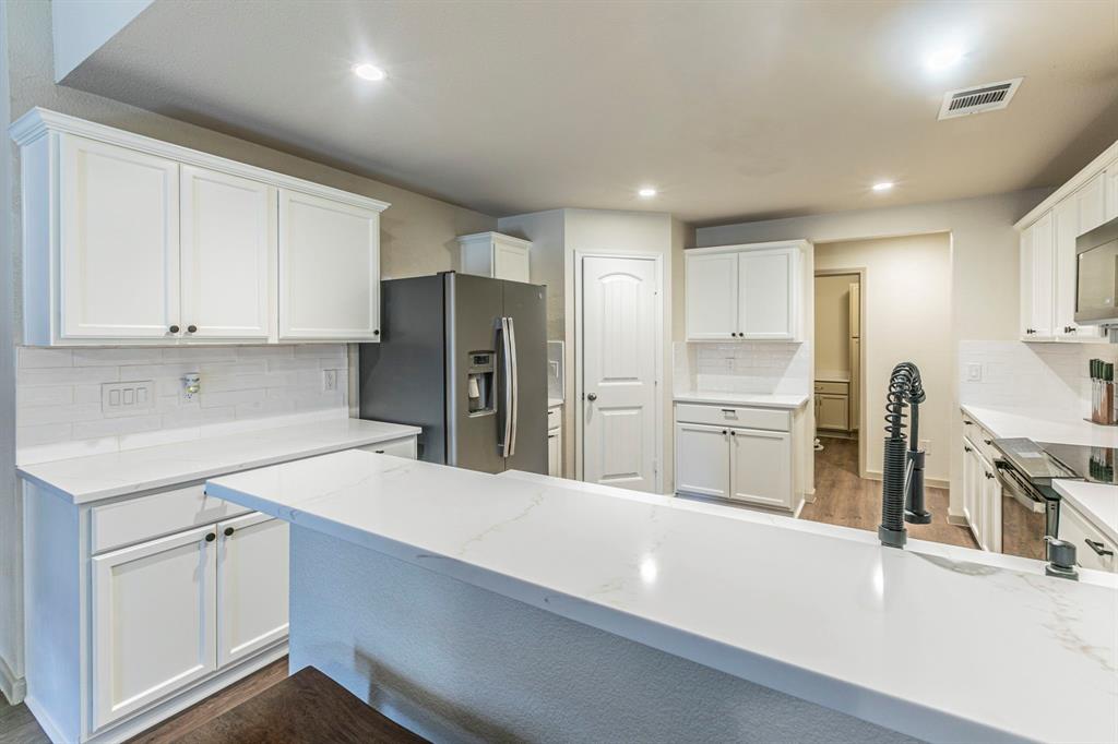 2210 Torch Lake Drive Forney, TX 75126 - Photo 8 of 29 a kitchen with a sink stainless steel appliances and white cabinets