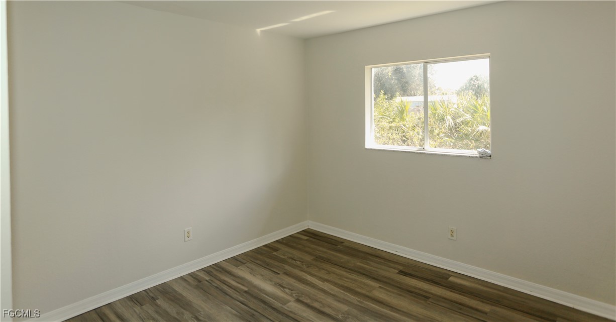 4612 25th Street Southwest Lehigh Acres, FL 33973 - Photo 11 of 15 an empty room with wooden floor and a window