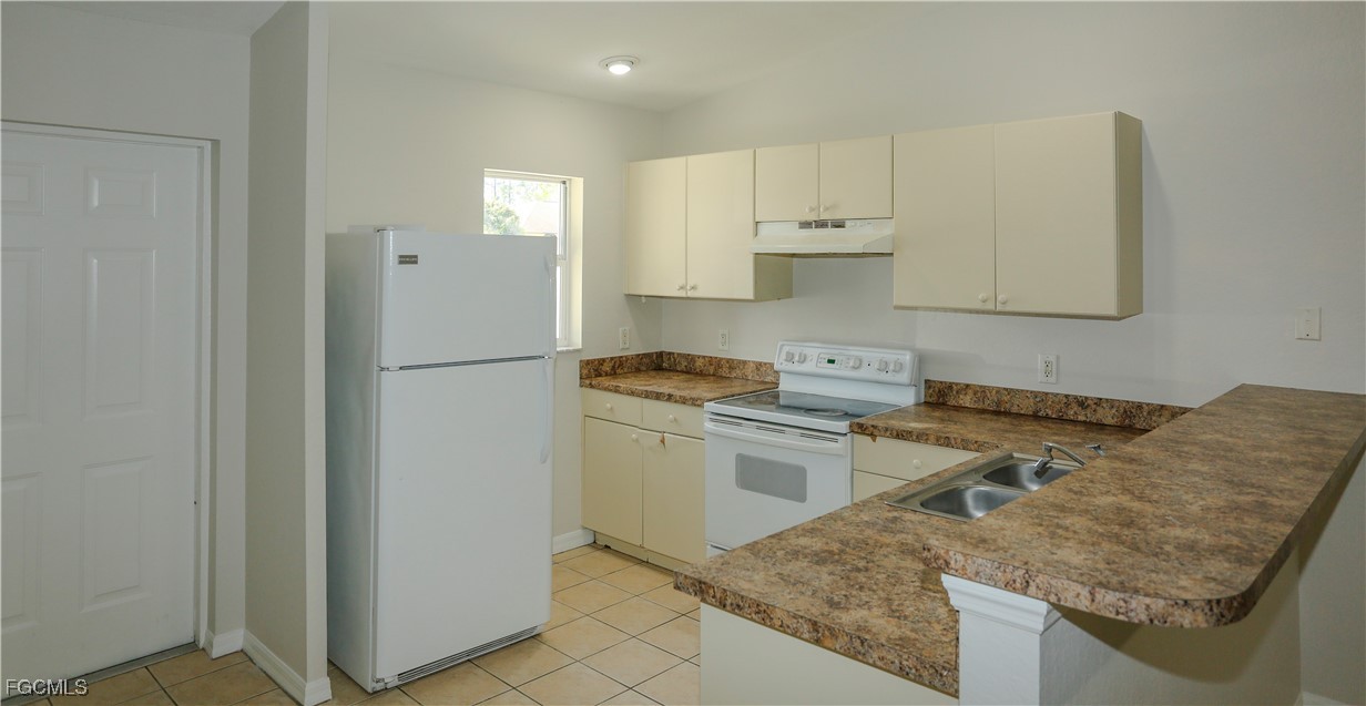 4612 25th Street Southwest Lehigh Acres, FL 33973 - Photo 6 of 15 a kitchen with a stove a refrigerator and a sink