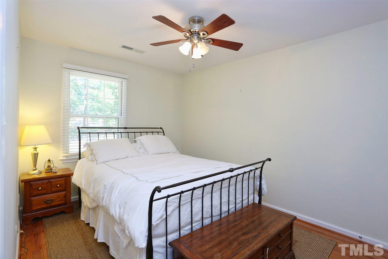 2860 Wycliff Road Raleigh, NC 27607 - Photo 13 of 25 a bedroom with a bed and a chandelier
