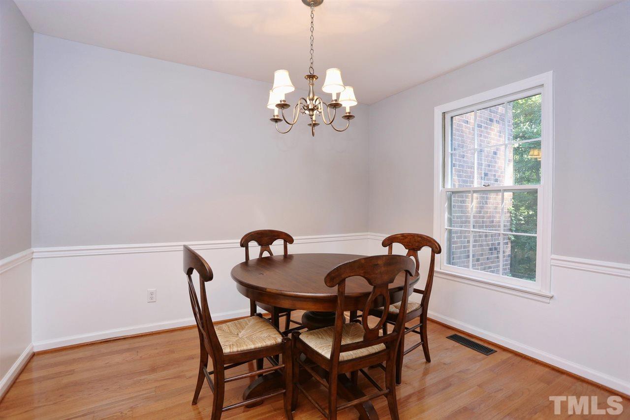 2860 Wycliff Road Raleigh, NC 27607 - Photo 4 of 25 a dining room with furniture a chandelier and wooden floor