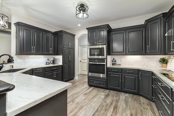 a kitchen with granite countertop wooden cabinets a stove top oven a sink and dishwasher