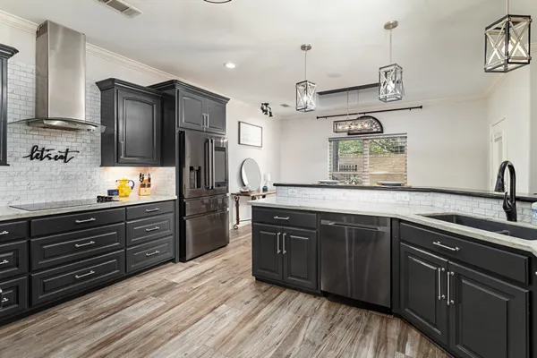 a kitchen with stainless steel appliances granite countertop a sink stove and refrigerator