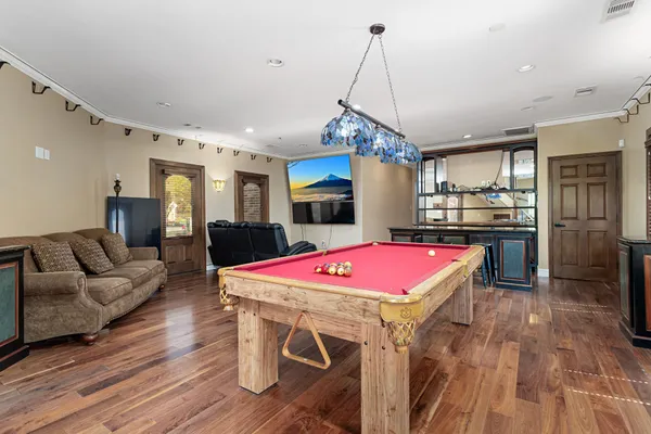 a kitchen with a refrigerator a stove top oven a sink dishwasher a dining table and chairs with wooden floor