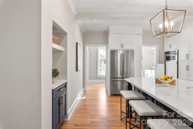 a hallway with a dining table wooden floor and a living room view