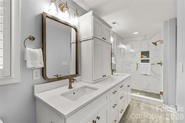 a bathroom with a double vanity sink mirror and shower
