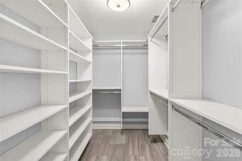 a view of walk in closet with empty racks