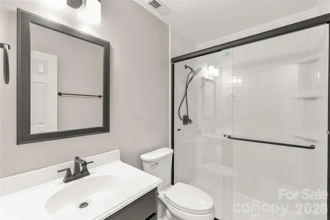 a bathroom with a sink mirror shower and toilet