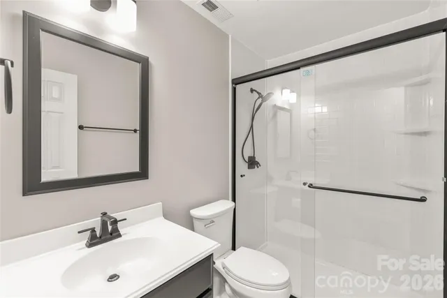 a bathroom with a sink mirror shower and toilet