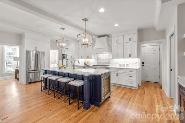 a large kitchen with lots of counter space a sink appliances and cabinets
