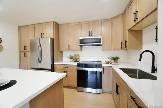 a kitchen with stainless steel appliances granite countertop a sink stove and refrigerator