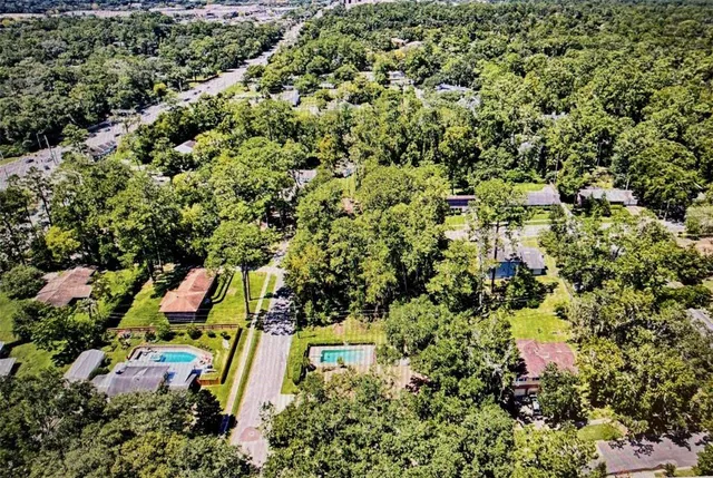 an aerial view of residential houses with outdoor space and trees