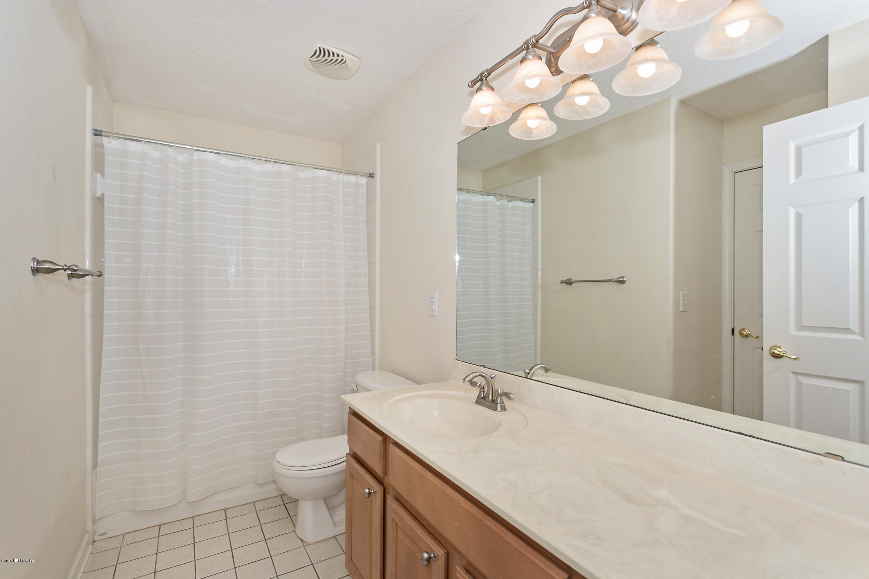 2809 Hidden Stagecoach Road Jacksonville, FL 32223 - Photo 17 of 25 a bathroom with a sink a toilet and a mirror
