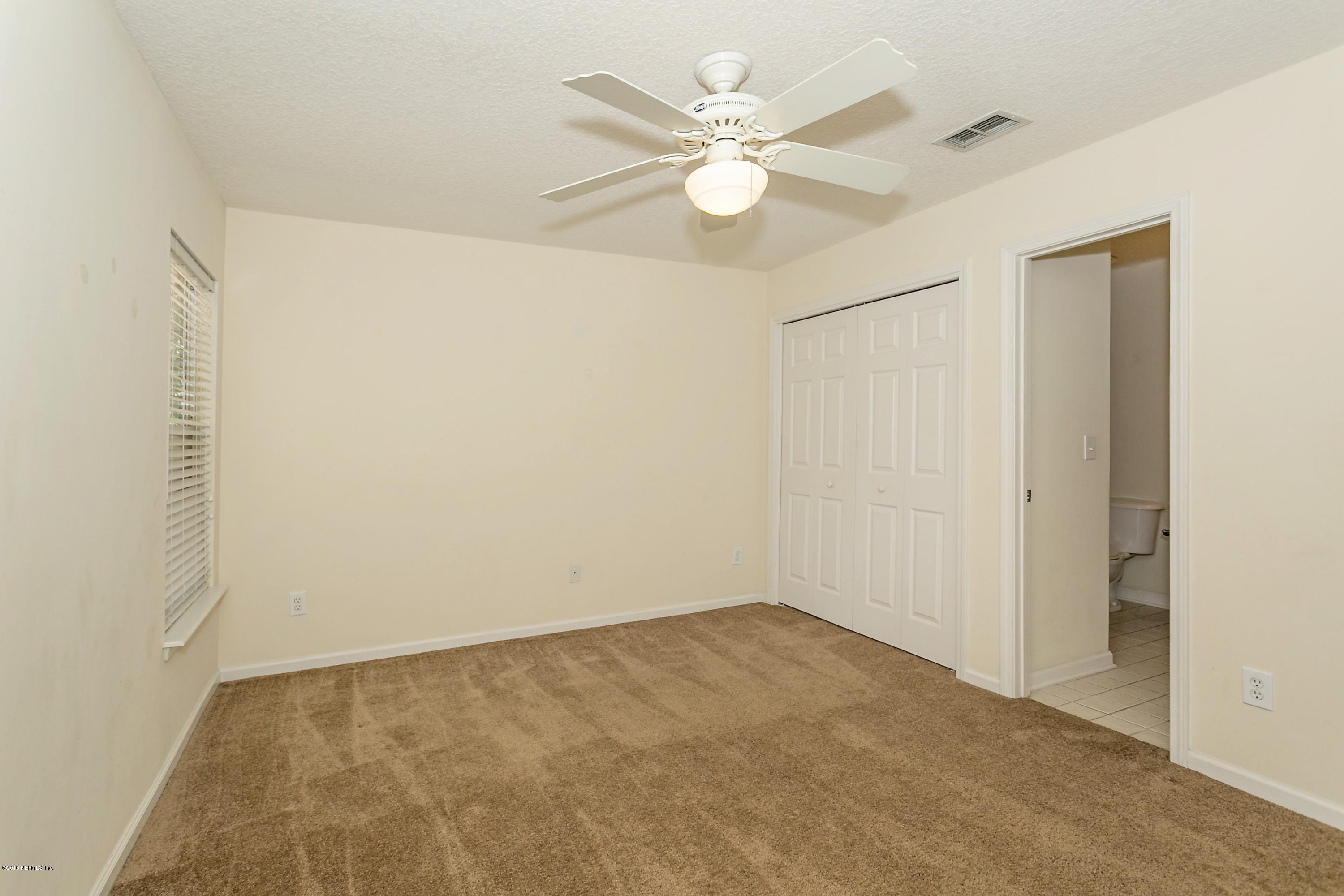 2809 Hidden Stagecoach Road Jacksonville, FL 32223 - Photo 18 of 25 an empty room with a chandelier fan and a window