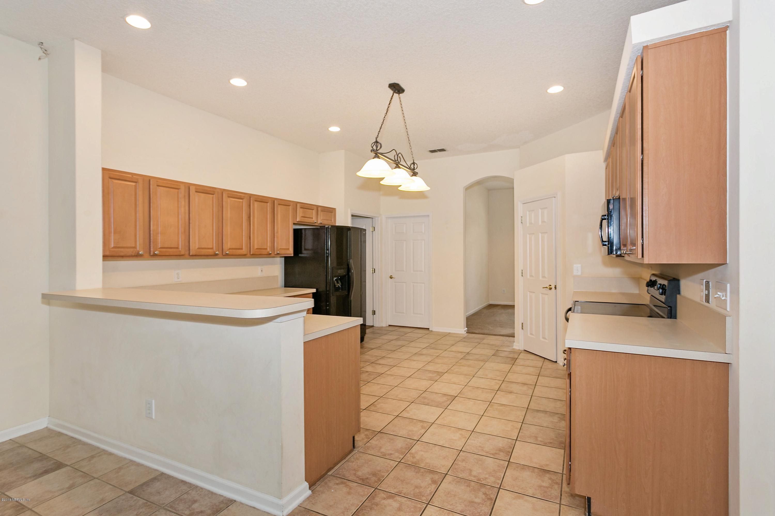 2809 Hidden Stagecoach Road Jacksonville, FL 32223 - Photo 5 of 25 a kitchen with kitchen island granite countertop a sink a counter top space and cabinets