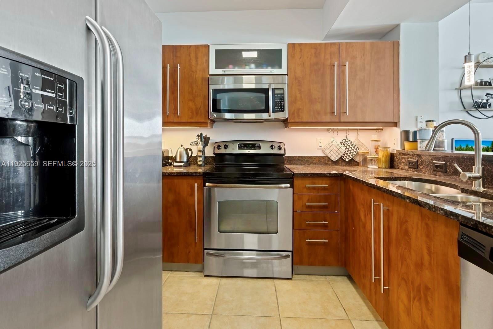 7350 Southwest 89th Street, Unit 607S Miami, FL 33156 - Photo 3 of 19 a kitchen with a stove microwave and sink