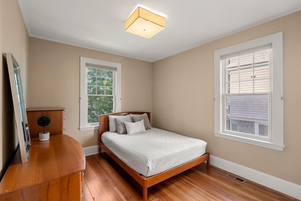 106 Westbourne Terrace, Unit 1 Brookline, MA 02446 - Photo 12 of 22 a bedroom with a bed and wooden floor