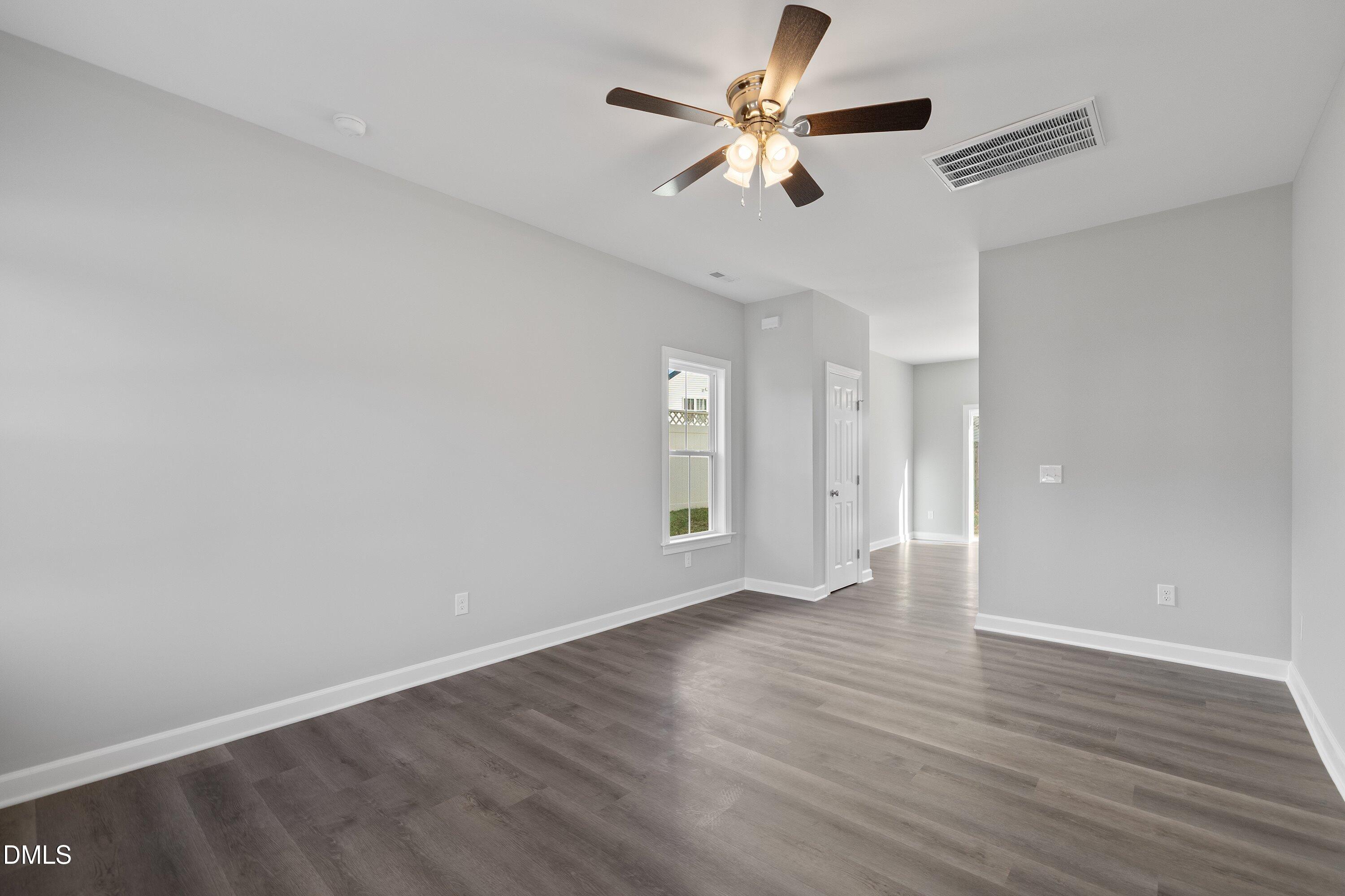 1808 Falls Landing Drive Raleigh, NC 27614 - Photo 7 of 23 an empty room with wooden floor and a ceiling fan