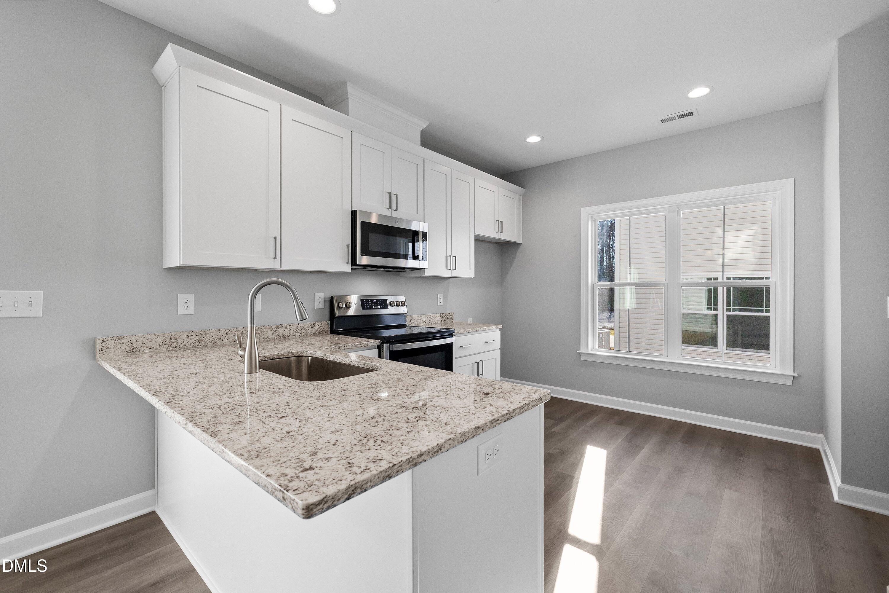 1808 Falls Landing Drive Raleigh, NC 27614 - Photo 8 of 23 a kitchen with granite countertop a sink a counter top space appliances and cabinets
