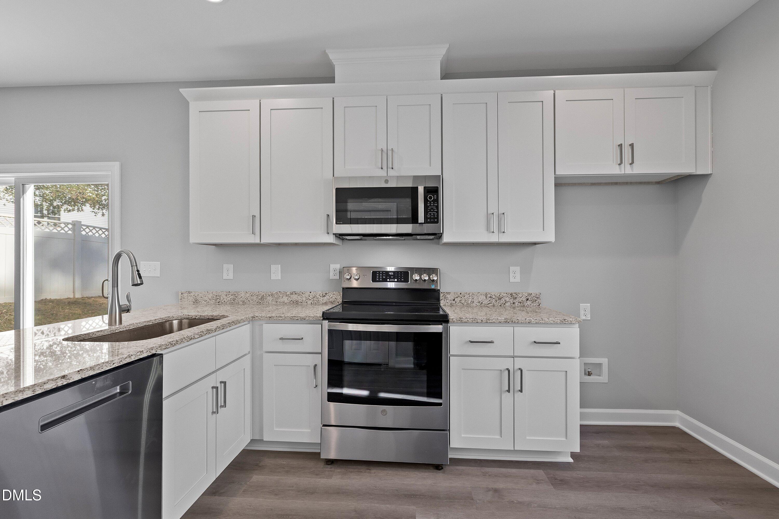 1808 Falls Landing Drive Raleigh, NC 27614 - Photo 9 of 23 a kitchen with stainless steel appliances granite countertop a stove a sink and a microwave
