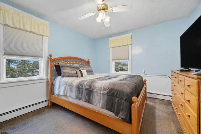 a bedroom with a bed and a flat tv screen on dresser