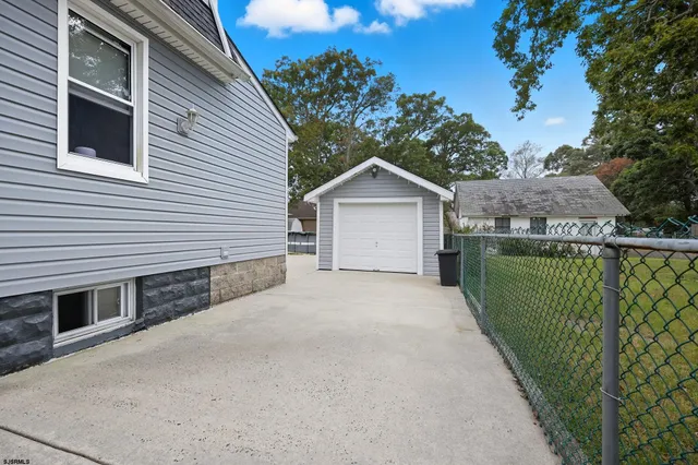a view of a house with a small yard and a large tree front
