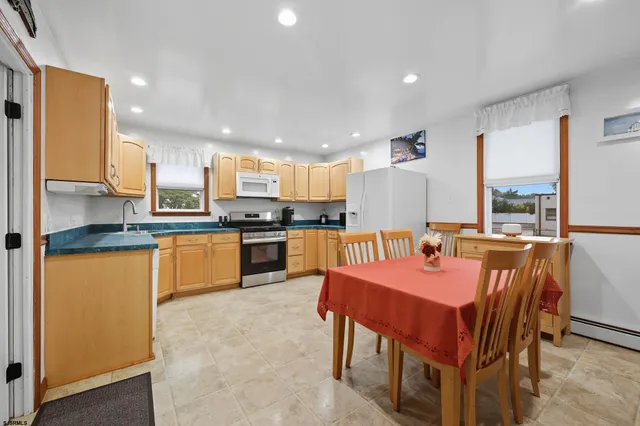 a large kitchen with a table and chairs