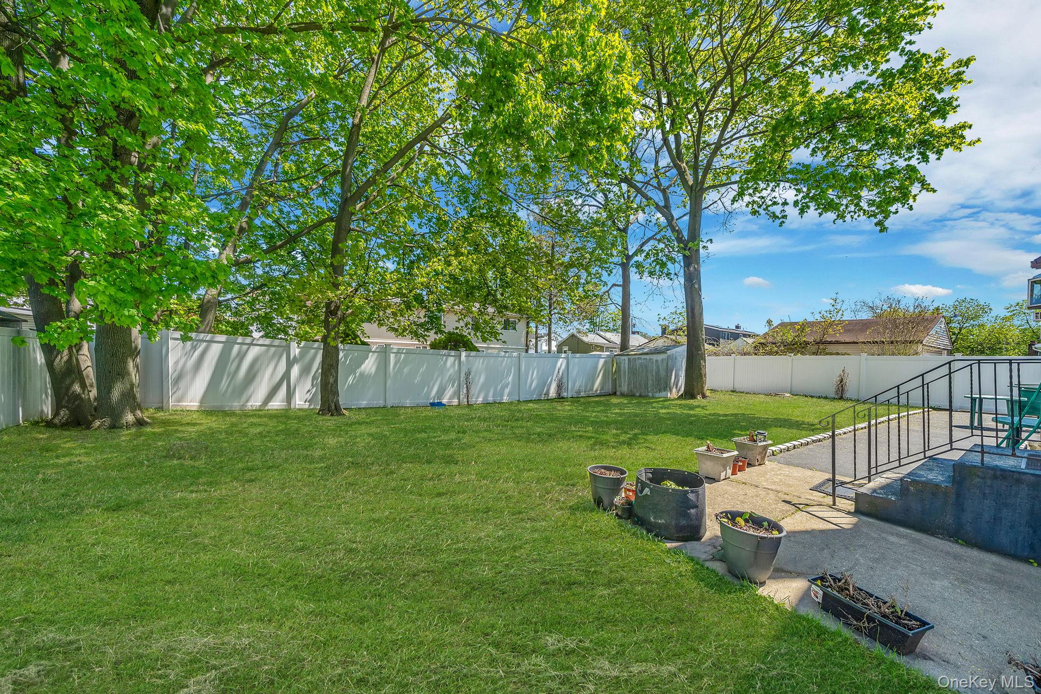1169 Little E Neck Road West Babylon, NY 11704 - Photo 28 of 28 a garden with a bench and trees